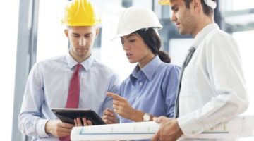 Drei Bauingenieure schauen auf ein Tablet