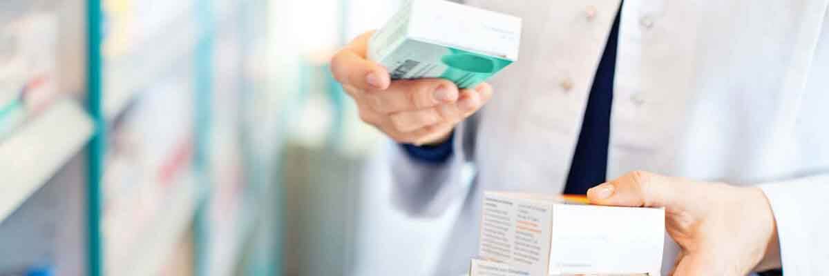 Apotheker hält Medikamentenpackungen in der Hand