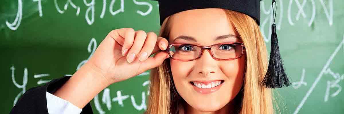 Junge Absolventin steht vor einer Tafel