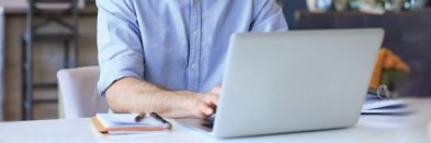 Bewerber schreibt Bewerbung per Mail an einem Laptop