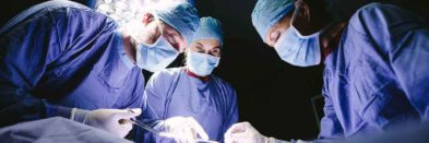 Gruppe von Chirurgen führt eine Operation in einem modernen Operationssaal durch.