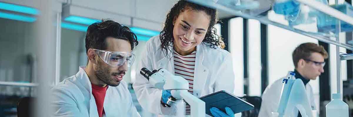 Gruppe von Laboranten arbeitet zusammen an wissenschaftlichen Forschungsprojekten in einem modernen Labor.