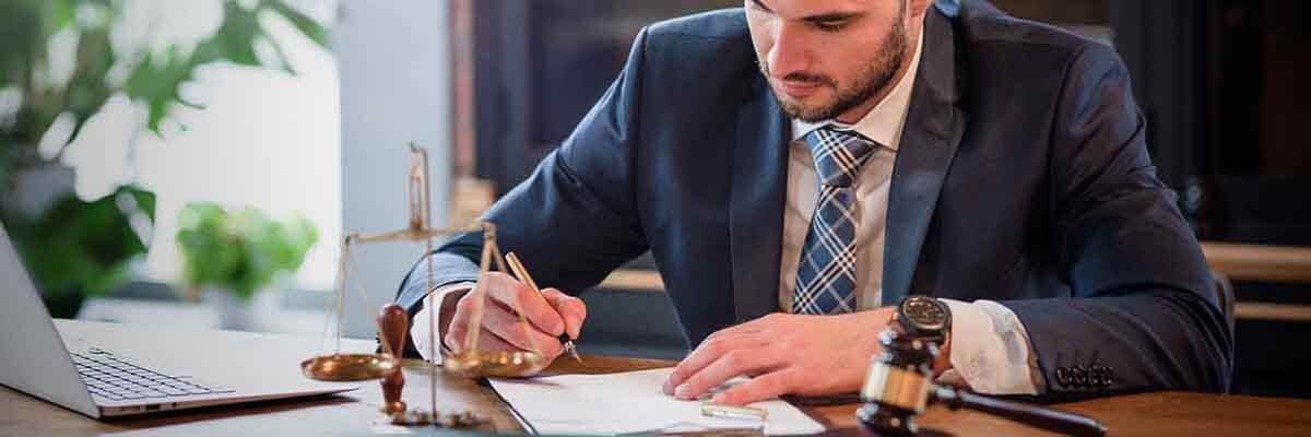 Patentanwalt Berufsbild – Aufgaben und Studium Anwalt arbeitet an Dokumenten in einem Büro mit Bücherregalen im Hintergrund.
