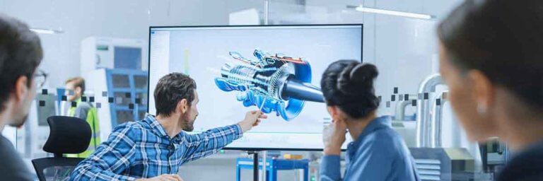 Wirtschaftsingenieur zeigt etwas an einem Maschinenteil auf einem Bildschirm