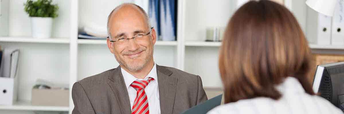Zufriedener Personalchef führt ein Vorstellungsgespräch mit einer Bewerberin in einem Büro.